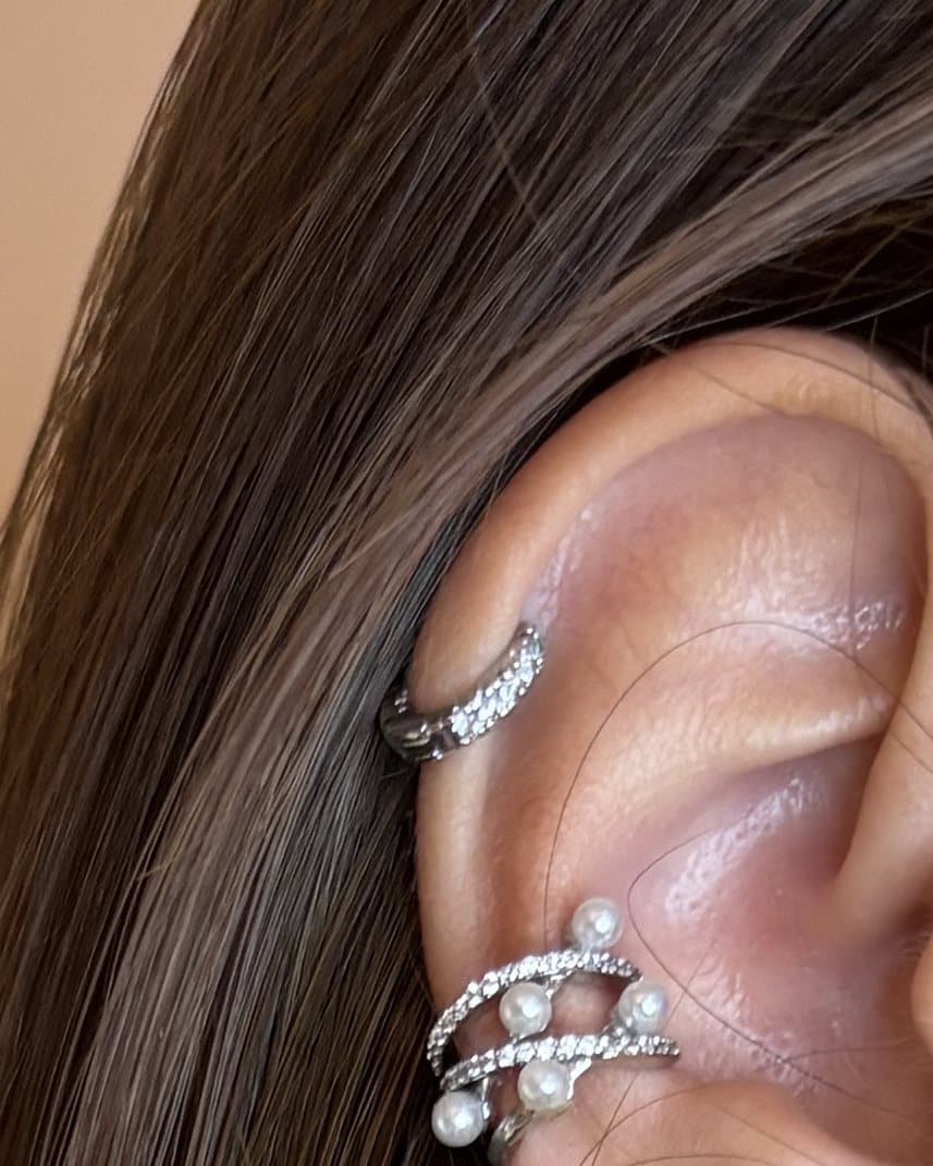 Ear cuff sottile in tono argento con zirconi, in alto sull'orecchio