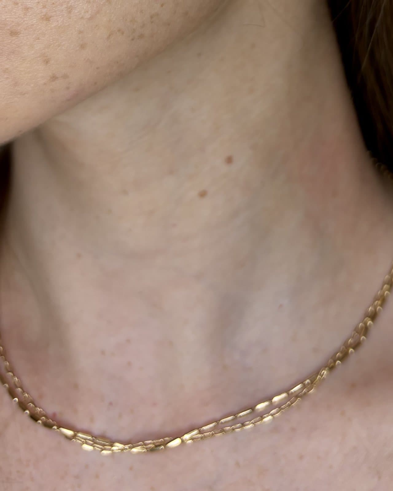 Collana dorata a due catene sottili, indossata