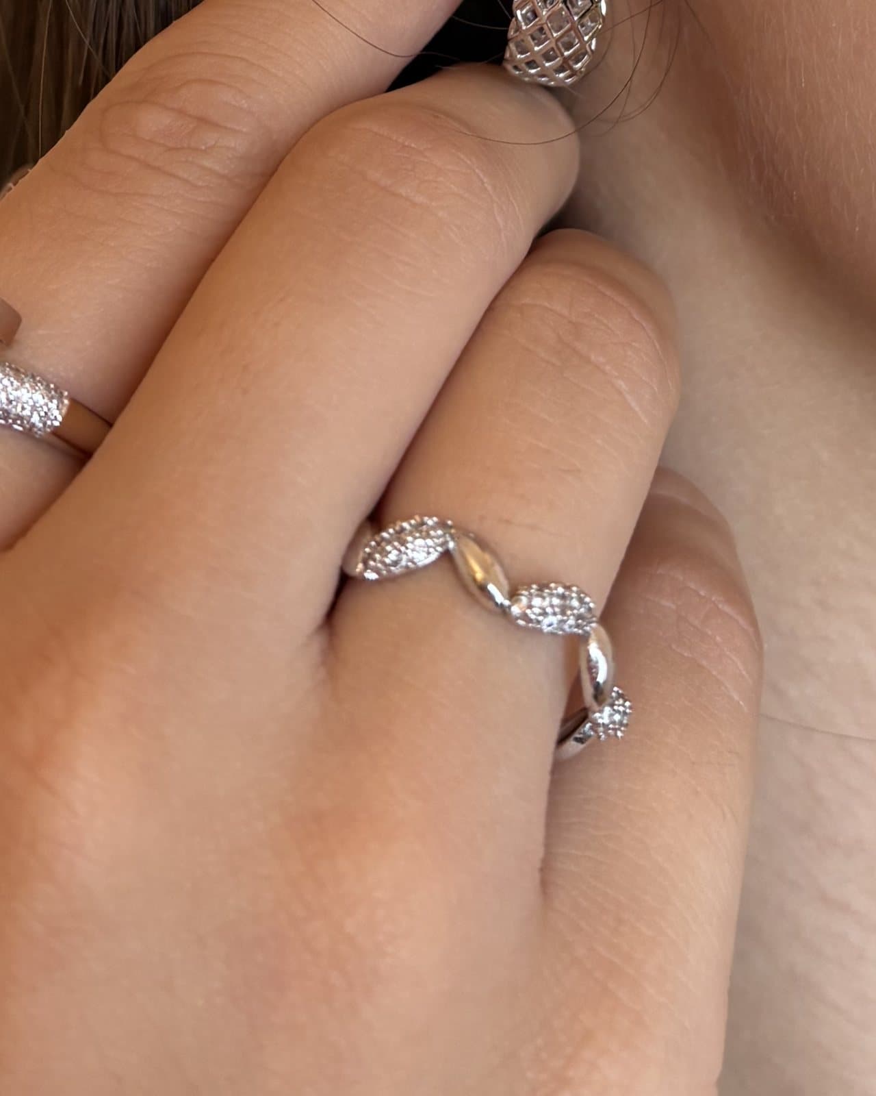 Anello ondulato in tono argento con zirconi, indossato
