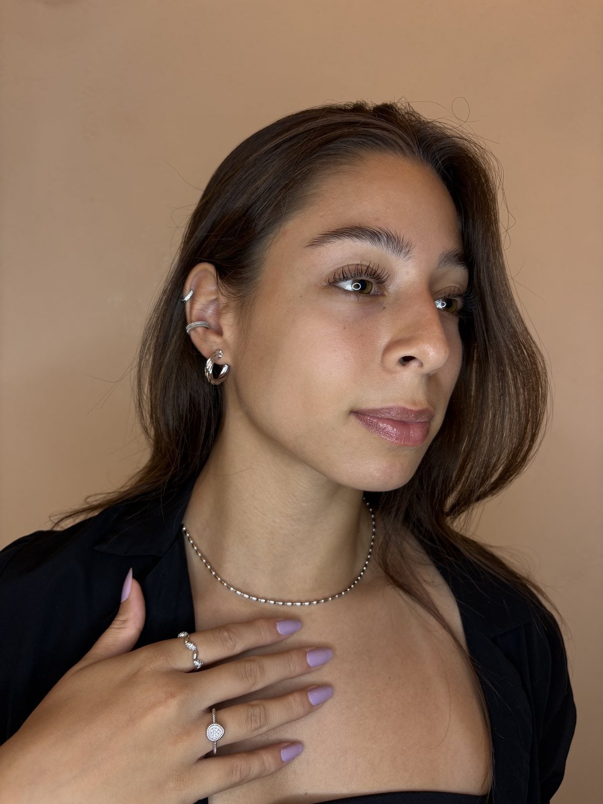 Ritratto con collana a grani, anelli e orecchini in tono argento