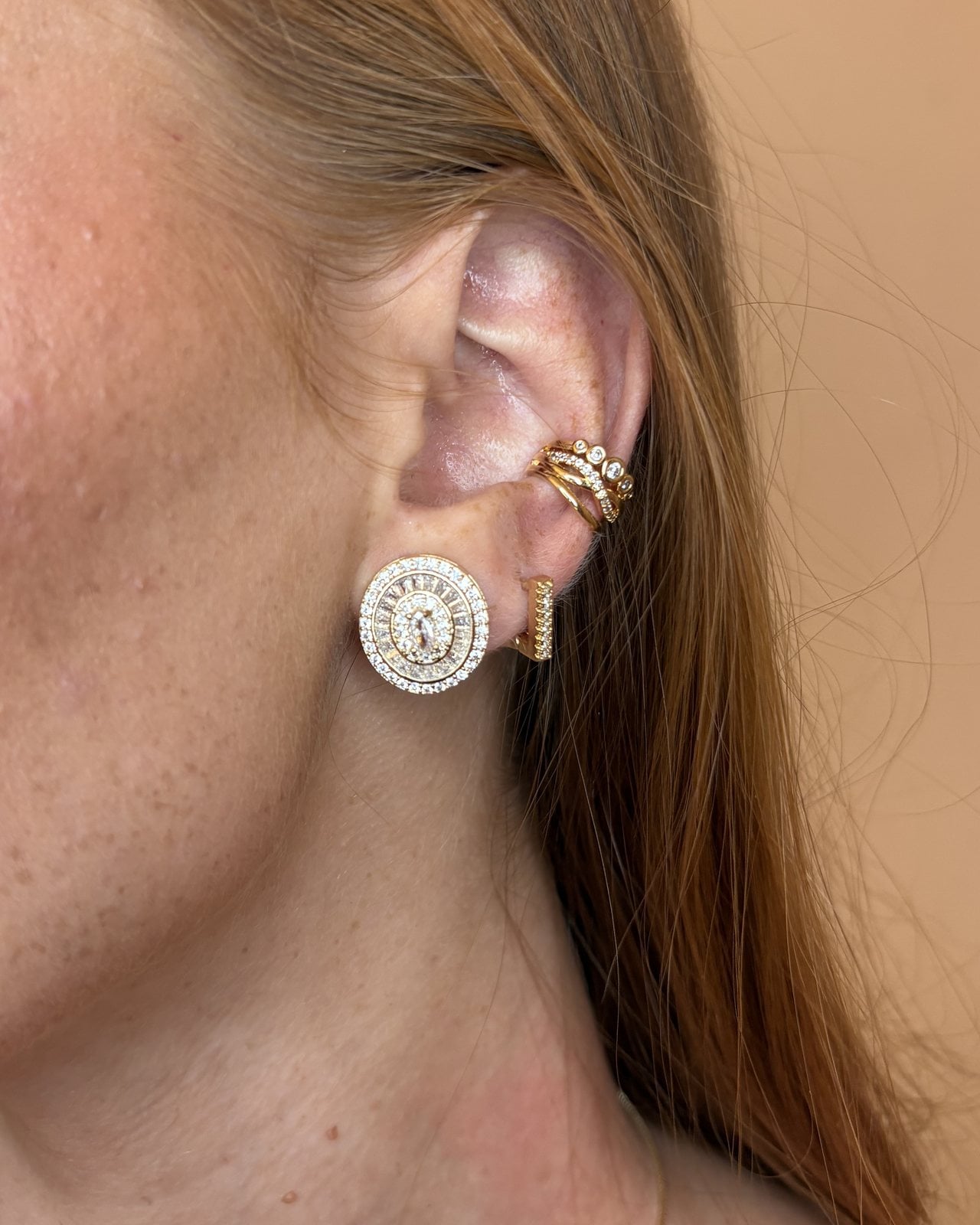 Orecchino a medaglione dorato con zirconi indossato, con ear cuff
