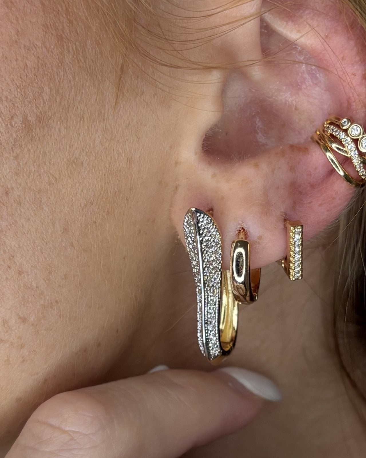 Orecchino allungato con pavé di zirconi e retro dorato lucido, indossato