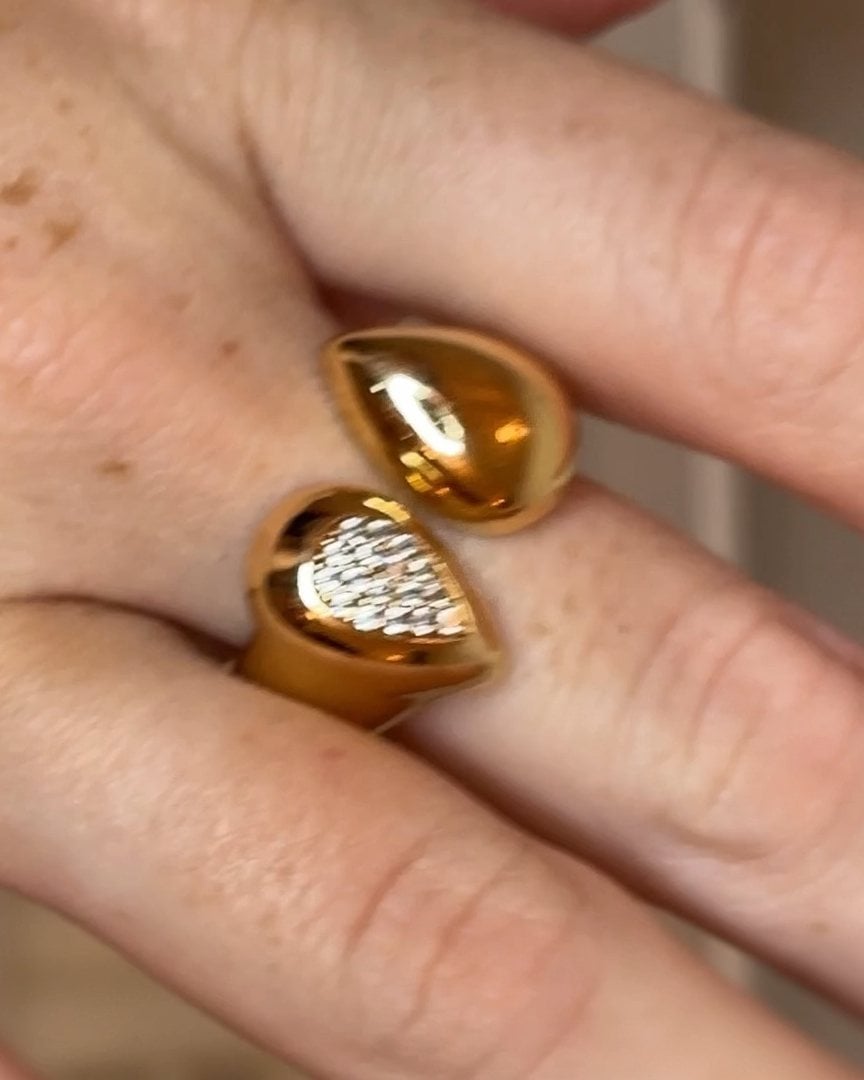Anello dorato con due gocce affrontate, una lucida e una con zirconi