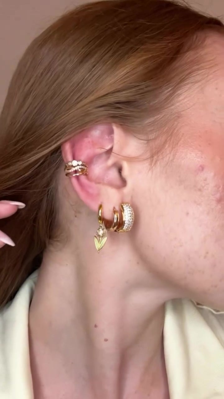 Primo piano dell'orecchio con ear cuff e cerchietti dorati