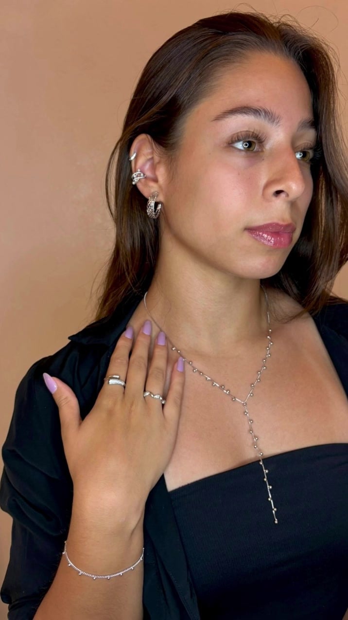 Ritratto con orecchini, anelli e collana a Y in tono argento